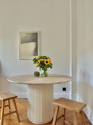 a vase of flowers on a table with two stools at Un cocon en centre ville de Nice 2 personnes in Nice