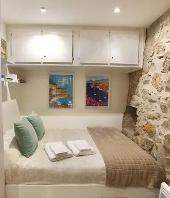 a bedroom with a bed with towels on it at Studio de charme - Vieille Ville - Proche plage in Villefranche-sur-Mer