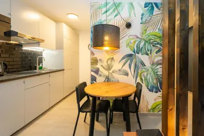 a kitchen with a wooden table and chairs at Victoria 2 People Parking AC WiFi in Nice