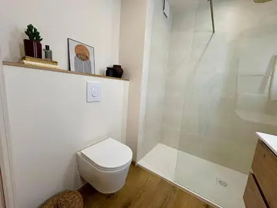 a white bathroom with a toilet and a shower at Studio cosy - Vue mer - Terrasse - Parking in Saint-Laurent-du-Var