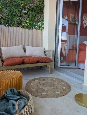 a couch sitting on a patio with a rug at T2 douillet proche de Nice - Accès plage à pied in Cagnes-sur-Mer