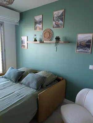 a bedroom with a bed with blue walls at T2 douillet proche de Nice - Accès plage à pied in Cagnes-sur-Mer