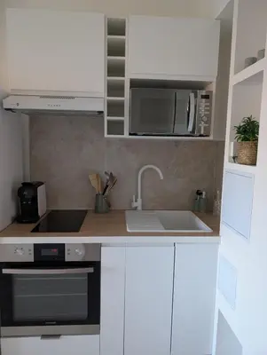 a kitchen with a sink and a microwave at T2 douillet proche de Nice - Accès plage à pied in Cagnes-sur-Mer
