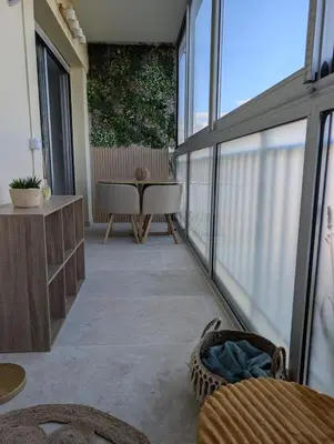 a balcony with a table and chairs and windows at T2 douillet proche de Nice - Accès plage à pied in Cagnes-sur-Mer