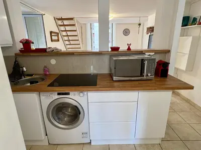 a kitchen with a microwave and a washing machine at Parenthèse Niçoise - Cœur de Nice in Nice