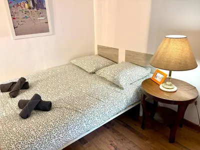 a bedroom with a bed with a lamp and a table at Parenthèse Niçoise - Cœur de Nice in Nice