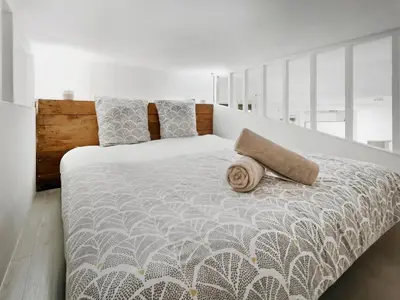 a bedroom with a large bed with a comforter and pillows at Studio moderne et douillet au cœur de Nice in Nice