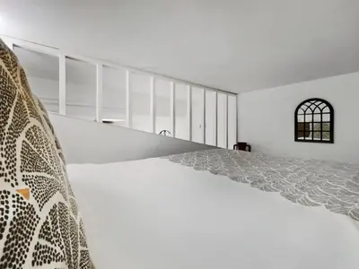 a white bedroom with a bed and a window at Studio moderne et douillet au cœur de Nice in Nice