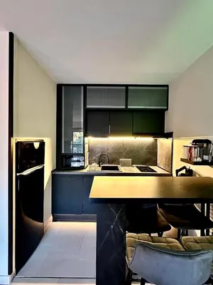 a kitchen with black cabinets and a counter top at Appartement moderne climatisé avec piscine, terrasse et parking - Proche Promenade des Anglais in Nice