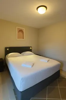 a bedroom with a large white bed with two pillows at Appartement moderne climatisé avec piscine, terrasse et parking - Proche Promenade des Anglais in Nice