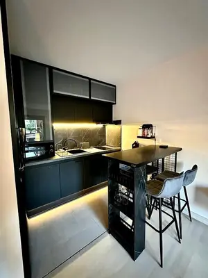 a kitchen with a counter and a table and chairs at Appartement moderne climatisé avec piscine, terrasse et parking - Proche Promenade des Anglais in Nice