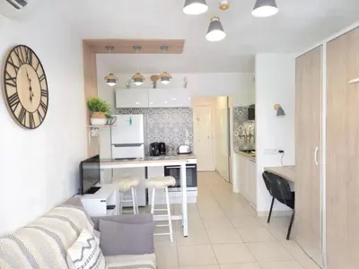 a kitchen and living room with a couch and a table at Cœur Libération Nice Studio in Nice