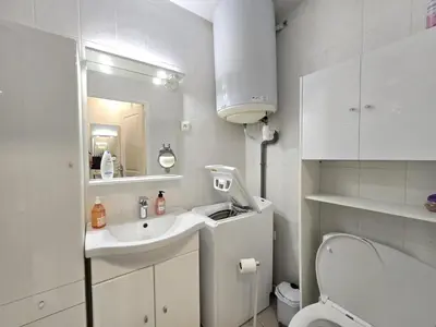 a white bathroom with a sink and a toilet at Cœur Libération Nice Studio in Nice