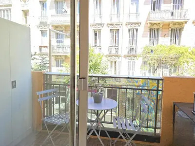 a balcony with a table and chairs and a building at Cœur Libération Nice Studio in Nice