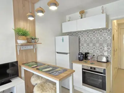 a small kitchen with a white refrigerator and a table at Cœur Libération Nice Studio in Nice