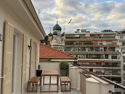 a balcony with a table and a view of a city at Oscar II in Nice