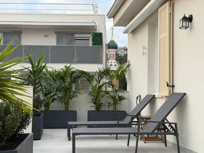 a patio with two chairs and a table on a balcony at Oscar II in Nice