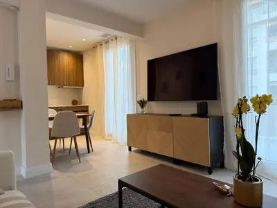 a living room with a flat screen tv on a wall at Oscar II in Nice