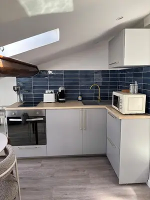 a kitchen with white cabinets and a microwave at Cocon lumineux sous les toits de Nice in Nice