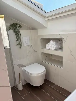 a bathroom with a white toilet and some towels at Cocon lumineux sous les toits de Nice in Nice