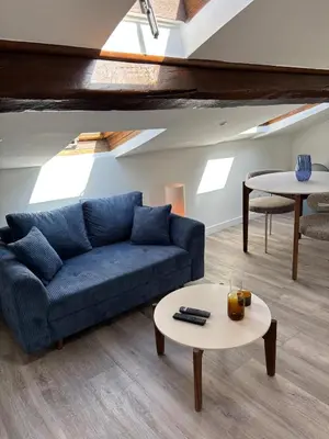 a living room with a blue couch and a table at Cocon lumineux sous les toits de Nice in Nice