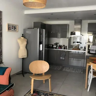 a kitchen with a table and a chair and a refrigerator at Port of Nice Terrace Apartment in Nice