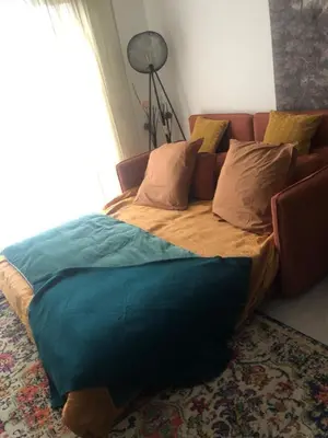 a bed in a living room with a couch at Port of Nice Terrace Apartment in Nice