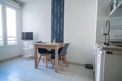 a kitchen with a table and chairs in a room at Bail mobilité - Beau studio proche tram Saint-Roch in Nice