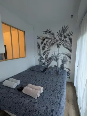a bedroom with a bed with a plant on the wall at Nice Cosy Garden in Nice
