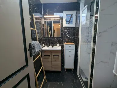 a bathroom with a sink and a mirror at Nice Cosy Garden in Nice