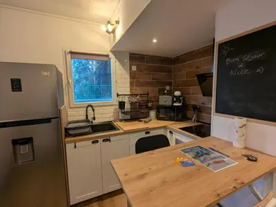a kitchen with a table and a chalkboard on the wall at Nice Cosy Garden in Nice
