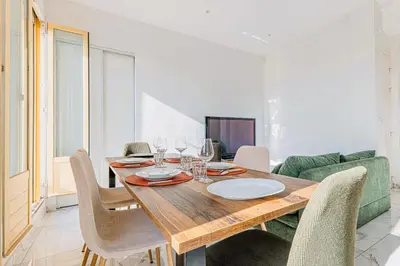 a dining room with a wooden table and chairs at Bail mobilité - Appartement 2 ch - Nice centre in Nice