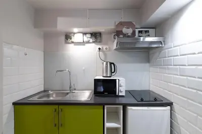 a small kitchen with a sink and a microwave at Studio indépendant en villa Calme, Jardins et Piscine à 5 min de la Mer in Nice