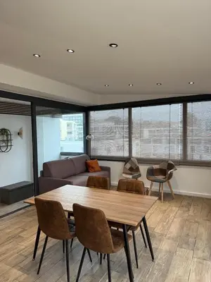 a living room with a table and a couch at Nid Azuréen – À deux pas de la plage, 6P in Saint-Laurent-du-Var