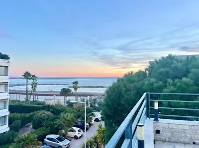 a view of the beach from a balcony of a building at Nid Azuréen – À deux pas de la plage, 6P in Saint-Laurent-du-Var
