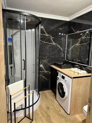 a bathroom with a shower and a washing machine at Nid Azuréen – À deux pas de la plage, 6P in Saint-Laurent-du-Var