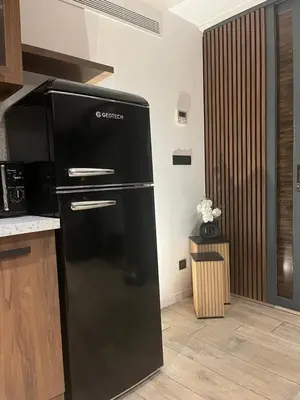 a black refrigerator in a kitchen next to a counter at Nid Azuréen – À deux pas de la plage, 6P in Saint-Laurent-du-Var
