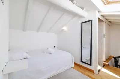 a living room with a table and a spiral staircase at Duplex à 2 min de la mer à pied in Nice