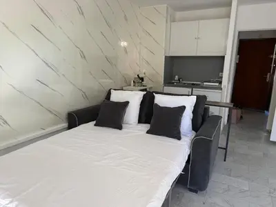 a large white bed with black pillows in a room at La Casa di Gio studio Cosy Tram et mer in Nice