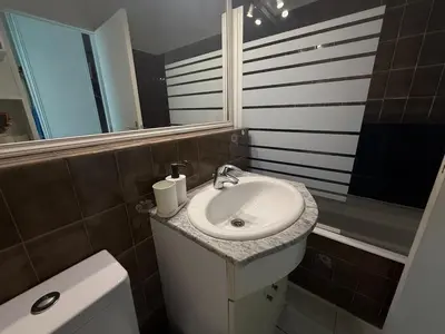 a bathroom with a sink and a toilet and a mirror at La Casa di Gio studio Cosy Tram et mer in Nice