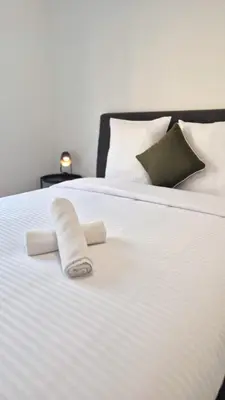 a white bed with two rolled towels on it at T3 neuf climatisé avec parking à Nice in Nice