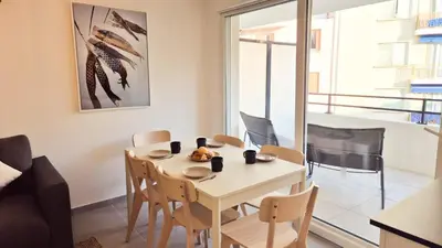 a dining room with a white table and chairs at T3 neuf climatisé avec parking à Nice in Nice