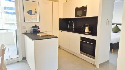 a kitchen with a counter and a sink and a microwave at T3 neuf climatisé avec parking à Nice in Nice