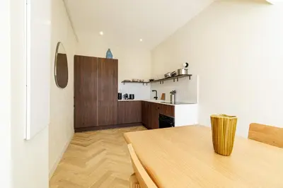 a kitchen with a wooden table in a room at 62 CARNOT LOT 2 - Un havre de paix climatise avec jardin et jacuzzi in Nice