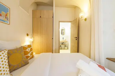 a bedroom with a large white bed and a hallway at 62 CARNOT LOT 2 - Un havre de paix climatise avec jardin et jacuzzi in Nice