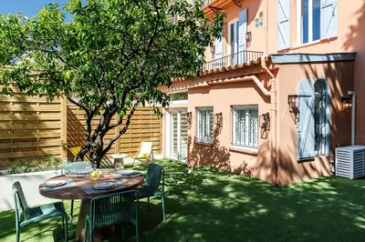 a table and chairs in a yard next to a building at 62 CARNOT LOT 2 - Un havre de paix climatise avec jardin et jacuzzi in Nice