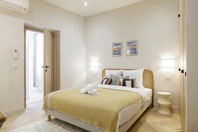 a bedroom with a large bed with a yellow blanket at 62 CARNOT LOT 5 - Appartement renove - climatise 2 chambres suites in Nice