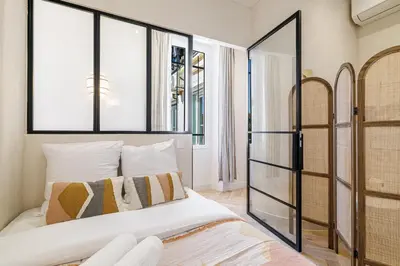 a bedroom with a king sized bed and windows at 62 CARNOT LOT 5 - Appartement renove - climatise 2 chambres suites in Nice