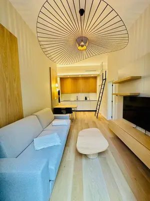 a living room with a blue couch and a table at Appartement neuf d architecte Carré d Or in Nice