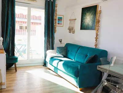 a blue couch in a living room with a window at T2 Cozy & Air-conditioned, close to All Amenities in Nice